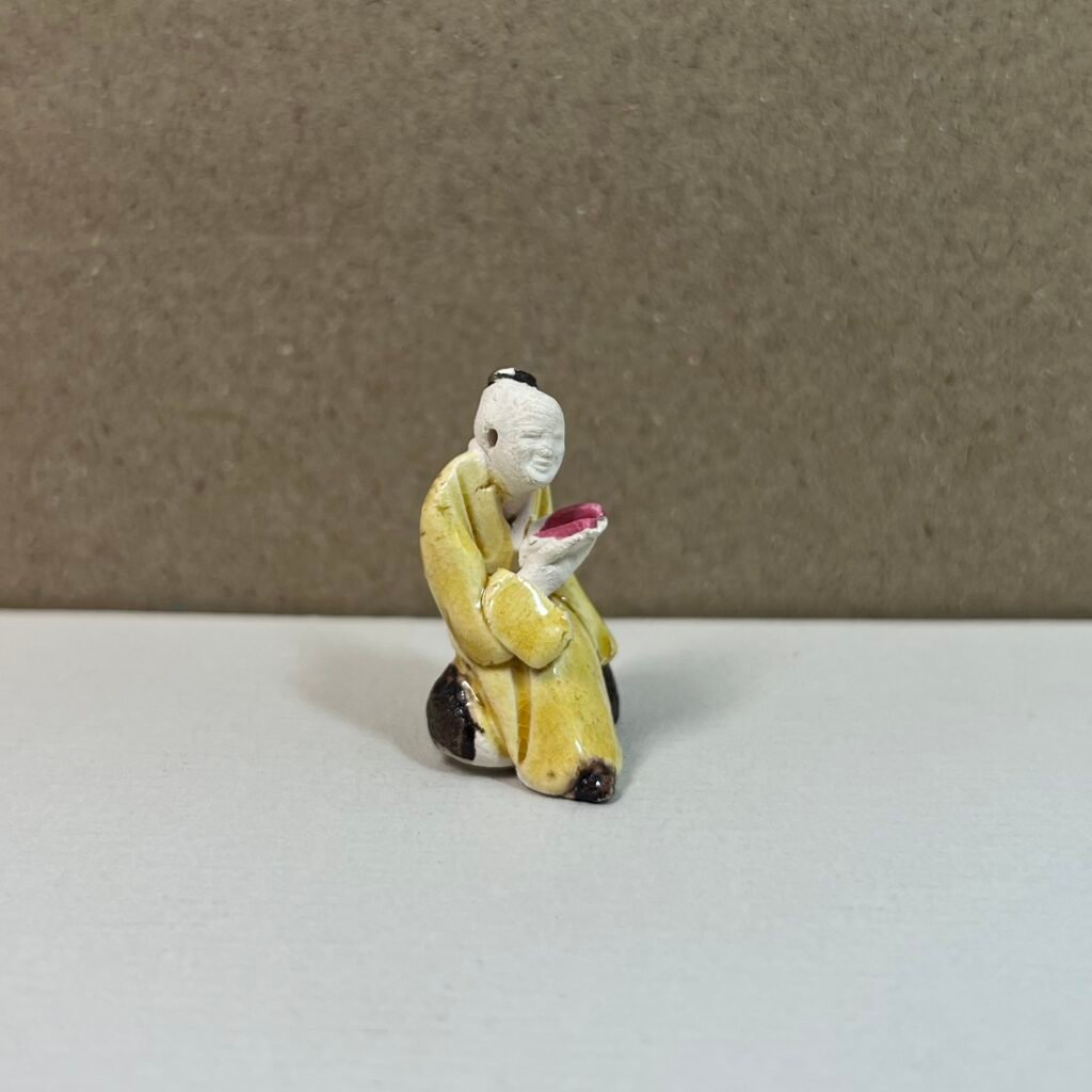 Small ceramic kneeling figurine