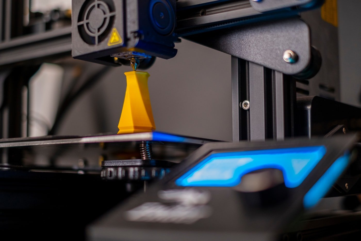A 3D printer producing a custom yellow component